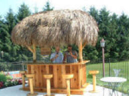 Kevin enjoying a cold beverage under a new tiki bar that he built