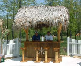 Authentic tiki bar complete with thatched roof and bar stools